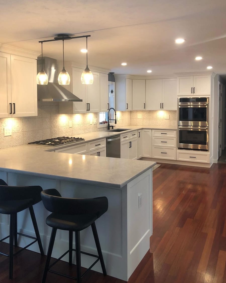 White kitchen with pendant, recessed, and under-cabinet lighting installed by Mike Mejia Electrical